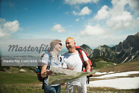 Mature couple looking at map, hiking in mountains, Tannheim Valley, Austria