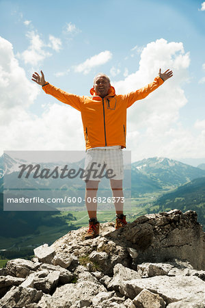 Mature man with arms raised in air, hiking in mountains, Tannheim Valley, Austria