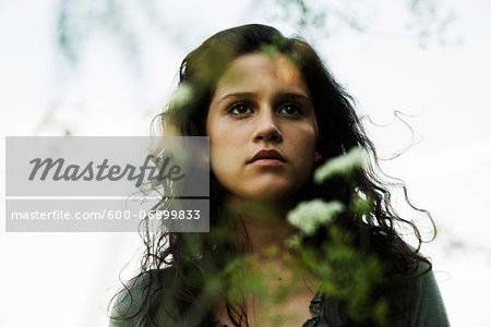 Portrait of teenaged girl outdoors in nature, looking into the distance, Germany