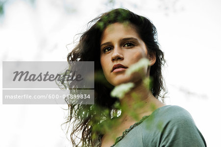 Portrait of teenaged girl outdoors in nature, looking into the distance, Germany