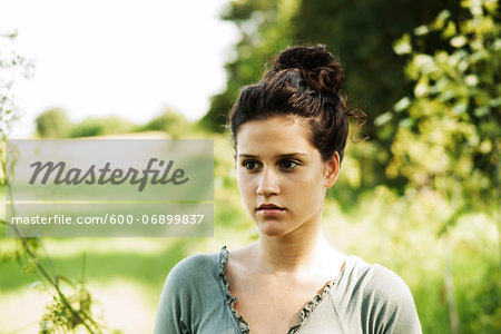 Portrait of teenaged girl outdoors in nature, looking into the distance, Germany