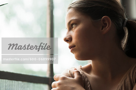 Girl looking out of window, Germany Girl looking out of window, Germany