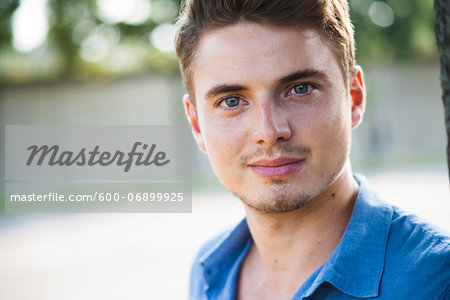 Close-up portrait of young man outdoors, looking at camera, Germany