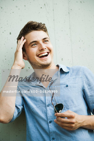 Portrait of young man outdoors, laughing, Germany