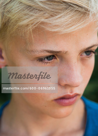 Close-up of boy outdoors, looking into the distance, Germany