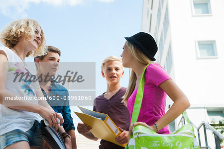 Group of teenagers standing outdoors talking, Germany