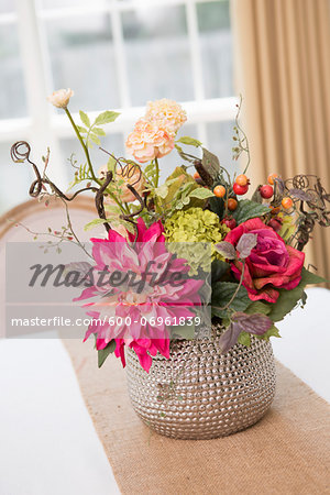 Floral centerpiece on table with burlap table runner