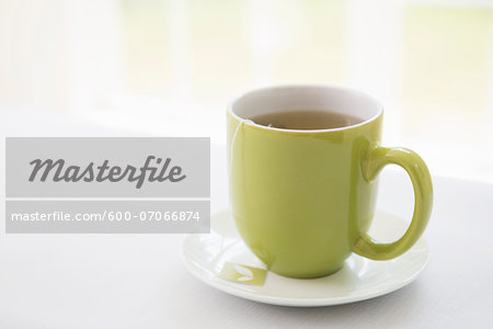 Cup of Tea in Green Mug with Saucer, Studio Shot