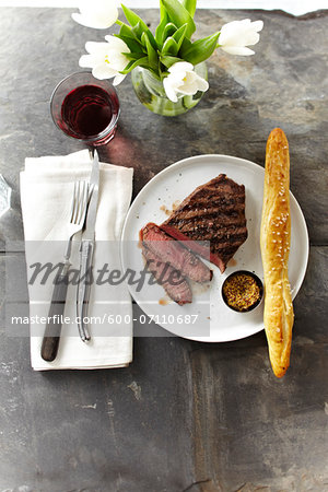Overhead View of Steak with Spicy Mustard and Breadstick, Studio Shot Overhead View of Steak with Spicy Mustard and Breadstick, Studio Shot