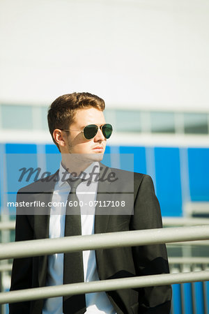 Young businessman wearing sunglasses, standing outdoors, Germany