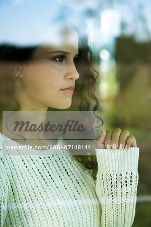 Close-up portrait of teenage girl looking out window, Germany