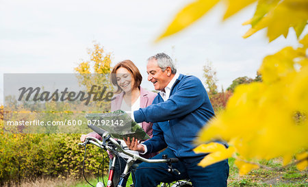 Couple with Bicycles Looking at Map in Autumn, Mannheim, Baden-Wurttemberg, Germany