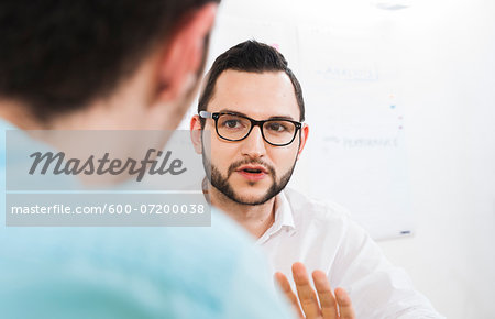 Close-up of two young businessmen meeting and in discussion, Germany