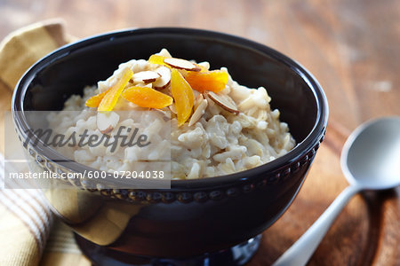 Single Serving Bowl of Brown Rice Pudding with Slivered Almonds and Dried Apricots with Spoon Single Serving Bowl of Brown Rice Pudding with Slivered Almonds and Dried Apricots with Spoon