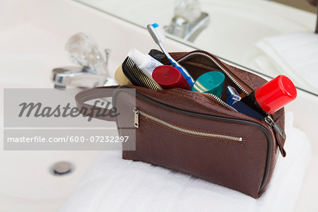 Men's Toiletry Travel Bag on Bathroom Counter filled with Personal Hygiene Products