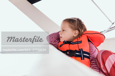 Close-up of 3 year old girl in orange life jacket on a motorboat, Sweden