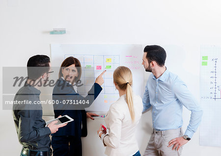 Group of young business people and mature businesswoman in discussion in office, Germany