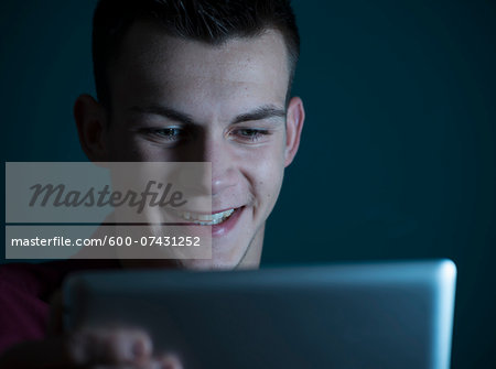 Young Man looking at Tablet Computer, Studio Shot