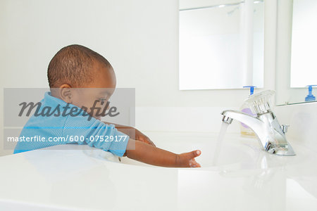 Toddler Washing his Hands in Bathroom Sink