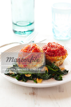 Mini Turkey Loaves with Sauce on Wilted Spinach on White Wooden Background, Studio Shot Mini Turkey Loaves with Sauce on Wilted Spinach on White Wooden Background, Studio Shot