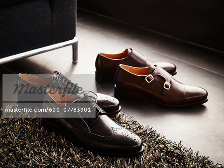 Two pairs of men's dress shoes on the floor, studio shot