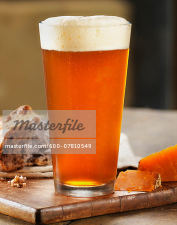 Glass of Beer with Bread and Cheese on Breadboard, Studio Shot
