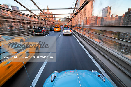 Driving over the Brooklyn Bridge in a VW Beetle towards Manhattan, New York City, New York, USA. Driving over the Brooklyn Bridge in a VW Beetle towards Manhattan, New York City, New York, USA.