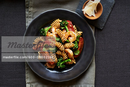 Fusilli pasta with shrimp and vegetables on a dark plate, studio shot Fusilli pasta with shrimp and vegetables on a dark plate, studio shot