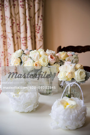 Small baskets of rose petals and bridal bouquets in vases on table, Wedding Day preparations, Canada