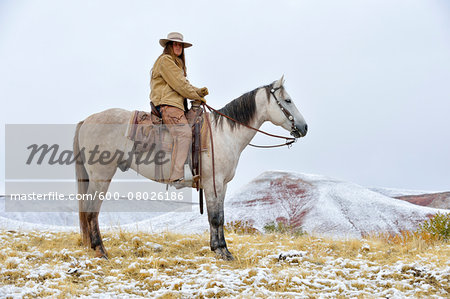 Cowgirl Riding Horse in Snow, Rocky Mountains, Wyoming, USA