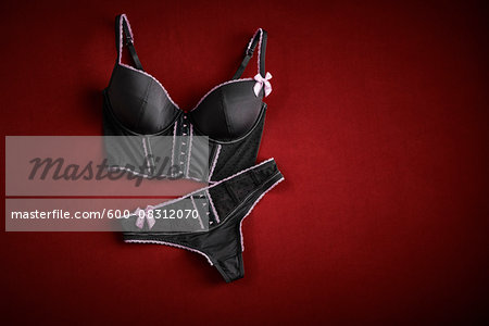 Bustier and thong on red background in studio