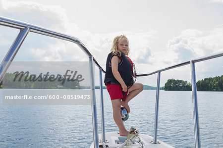Boy Standing on Nose of Boat on Lake, Sweden