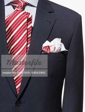 Detail of a dark blue suit jacket with red and white striped necktie and handkerchief and striped shirt