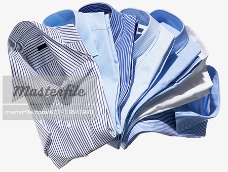 Group of blue and striped men's dress shirts on white background