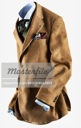 Tan colored sports jacket with blue striped shirt and colourful handkerchief, with green sweater and necktie on white background