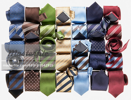 Group of multi coloured neckties roled-up on white background