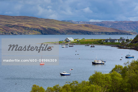 Boats achored in small harbor in a sea bay on the Isle of Skye in Scotland, United Kingdom