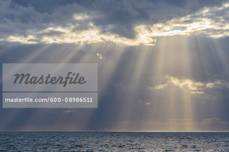 Crepuscular sunrays shining through the clouds over the North Sea, United Kingdom Crepuscular sunrays shining through the clouds over the North Sea, United Kingdom