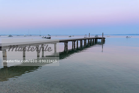 Wooden jetty on Lake Gardo (Lago di Garda) at dawn in Bardolino in Veneto, Italy