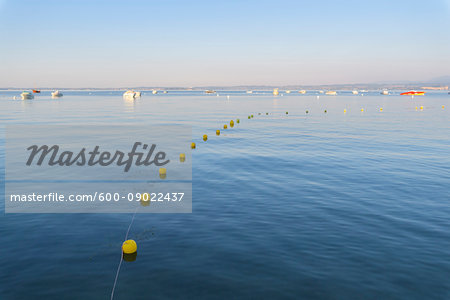 Lake Garda (Lago di Garda) with line of buoys and boats anchored in the distance at Bardolino in Veneto, Italy