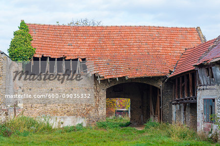 Old stone barn with broken corrugated roof in Hesse, Germany