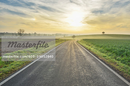 Morning sun shining over a country road in Freiensteinau in the Vogelsberg District in Hesse, Germany