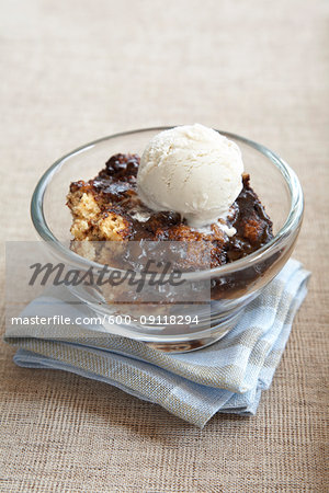 Warm vanilla and chocolate cake with vanilla ice cream in a small glass bowl
