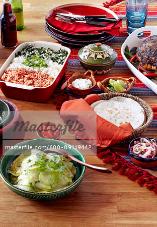 Mexican holiday feast with roast pork and dishes of rice, salad and tortillas