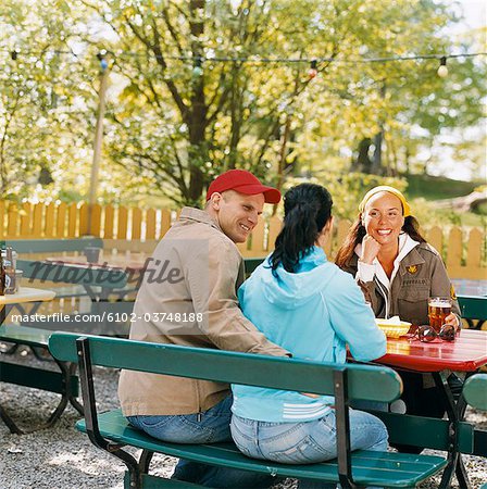 Three friends in an open-air restaurant.