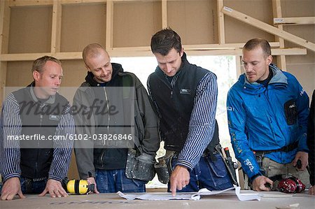Four carpenters discussing a drawing, Stockholm, Sweden.