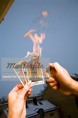 A person setting tarot cards on fire, Sweden.