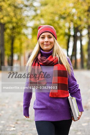 A woman walking in a park in autumn, Sweden.