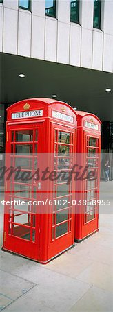 Two red telephone booths in front of building