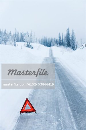 A warning triangle on a country road in the winter, Sweden.